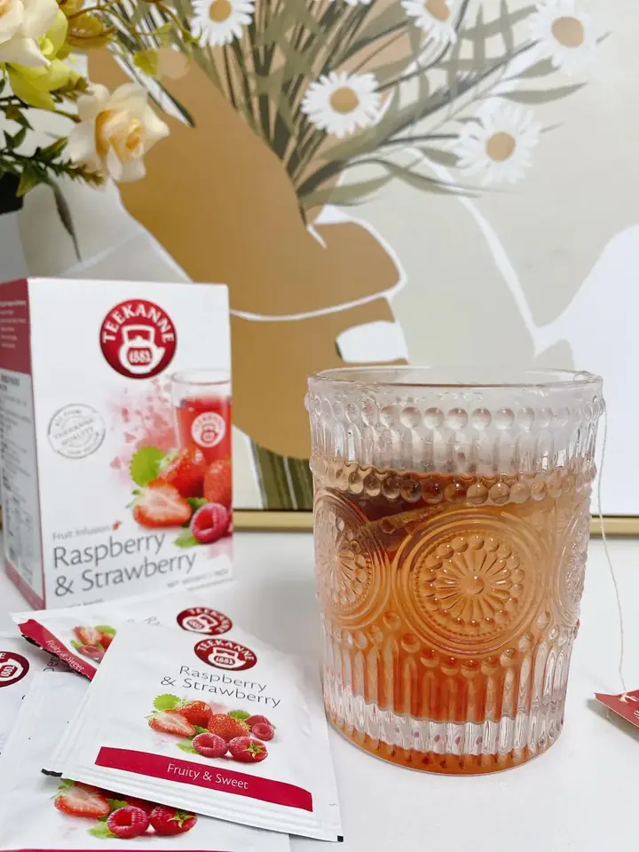 TEEKANNE Raspberry & Strawberry product and brewed tea presented in a lifestyle setting.