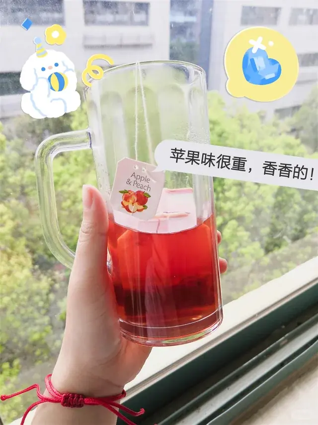 Consumer photo of a TEEKANNE Apple & Peach tea bag steeping in a glass mug.